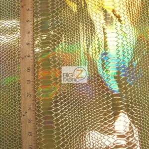 Pu&ograve; includere: Tessuto effetto pelle di serpente dorato iridescente con un motivo testurizzato. Il tessuto &egrave; misurato con un righello in pollici.