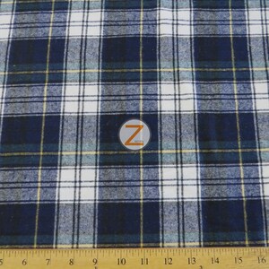 May include: A close-up of a blue and white plaid fabric with thin yellow stripes. The fabric is measured with a ruler in inches.