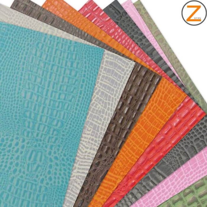 Op de afbeelding: Assortiment van 10 vellen kunstleer in verschillende kleuren, waaronder turquoise, wit, bruin, oranje, rood, grijs, roze en groen. Elk vel heeft een krokodil-reli&euml;fpatroon.