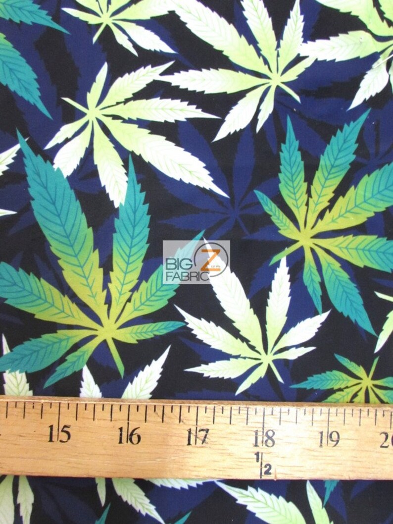 Puede incluir: Una tela azul oscuro con un patr&oacute;n repetido de hojas de marihuana verdes y blancas. Una regla se coloca en la parte inferior de la imagen, mostrando medidas en pulgadas.