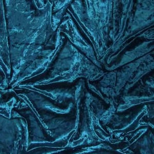 May include: Teal crushed velvet fabric with a soft, luxurious texture. The fabric is draped and folded, showcasing its flowing and elegant qualities.