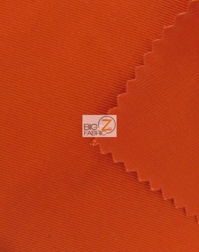 May include: Close-up of a bright orange fabric with a textured weave. The fabric is folded over on itself, creating a diagonal line.