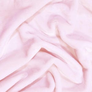 May include: A soft, pink fabric with a smooth, silky texture. The fabric is draped and folded, creating a gentle, flowing effect.