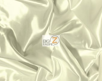 May include: A close-up of ivory satin fabric with a smooth, silky texture. The fabric is draped and folded, showcasing its luxurious drape and sheen.