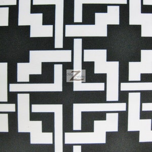 May include: Black and white geometric fabric with a repeating pattern of interlocking L shapes.