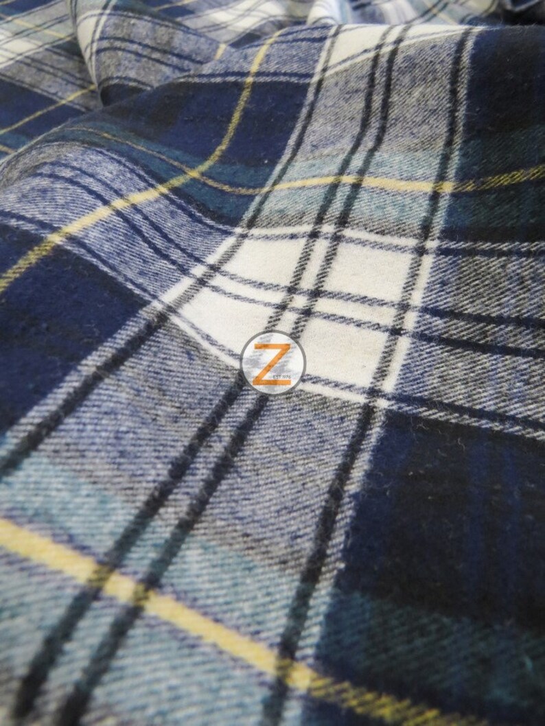 May include: Close-up of a blue, white, and yellow plaid fabric. The fabric has a soft, textured feel and is perfect for crafting projects.