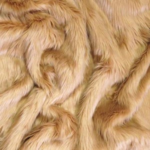 May include: A close-up of a soft, plush, light brown faux fur fabric. The fur is long and fluffy, creating a luxurious and cozy texture.