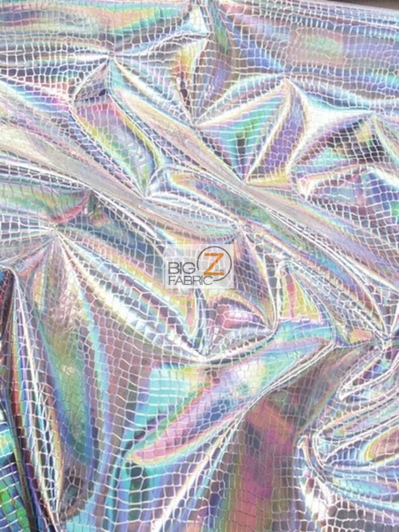 May include: A close-up of iridescent silver fabric with a crocodile skin pattern. The fabric is textured and has a shimmering effect.