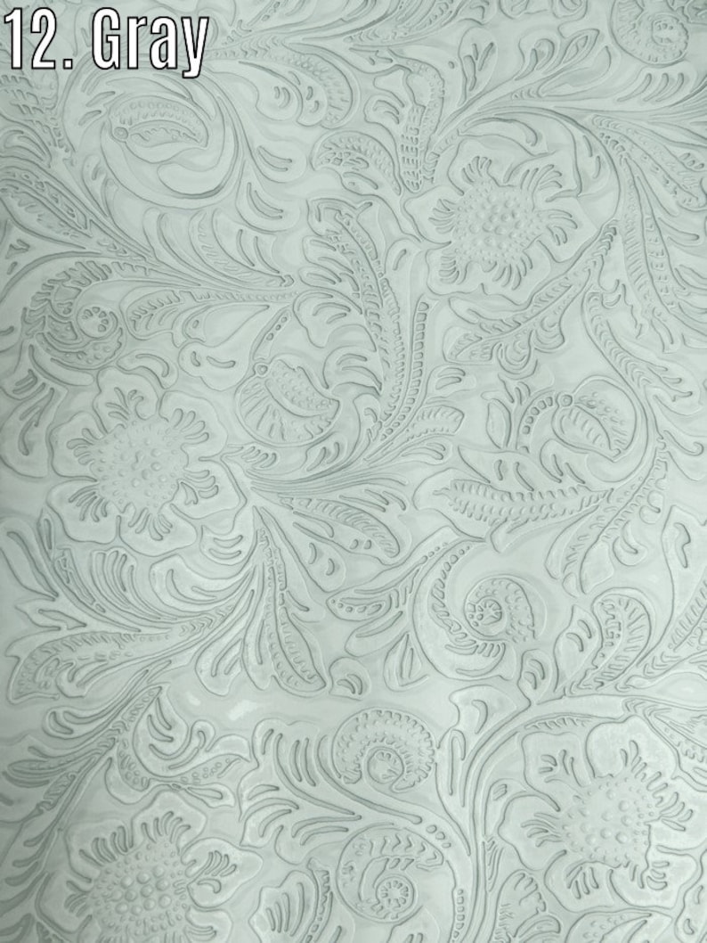 May include: A close-up of a light gray embossed fabric with a floral pattern. The fabric has a textured surface and a subtle sheen.