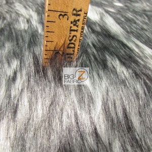 Może przedstawiać: Zbliżenie na czarną i białą tkaninę z imitacji futra z linijką mierzącą 7,6 cm. Tkanina ma miękką, puszystą fakturę i idealnie nadaje się do prac ręcznych.