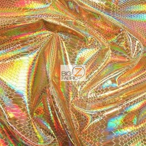 Pu&ograve; includere: Primo piano di un tessuto dorato iridescente con un motivo a pelle di serpente. Il tessuto ha una finitura olografica ed &egrave; testurizzato.