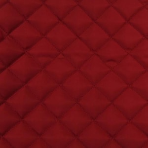 May include: Close-up of a quilted fabric in a deep red color. The fabric features a diamond pattern created by stitched lines. The texture appears soft and smooth, with subtle variations in the color.