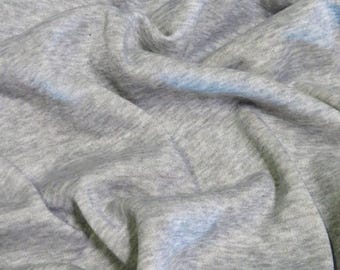 Puede incluir: Primer plano de una tela gris texturizada. La tela es suave y tiene un aspecto ligeramente arrugado.