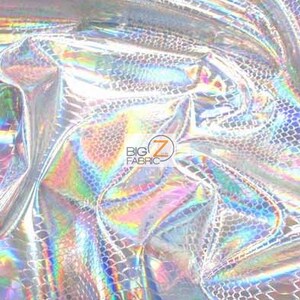 Pu&ograve; includere: Primo piano di un tessuto argentato iridescente con un sottile motivo a squame. Il tessuto ha una finitura olografica che brilla con colori arcobaleno.