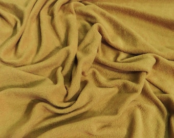 May include: A close-up of a soft, mustard yellow fleece fabric. The fabric is folded and draped, showing its texture and color.