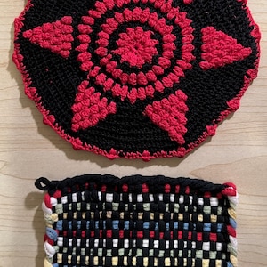 Puede incluir: Dos artículos de cocina hechos a mano: un salvamanteles negro y rojo de ganchillo con un diseño de estrella y un salvamanteles cuadrado tejido con un patrón de cuadros colorido. Ambos artículos están diseñados para resistir el calor.