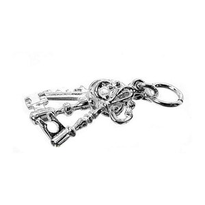 Puede incluir: Un dije plateado con dos llaves ornamentadas. Las llaves tienen dise&ntilde;os detallados, incluyendo un elemento en forma de coraz&oacute;n y patrones decorativos. Un peque&ntilde;o anillo est&aacute; adjunto para facilitar la fijaci&oacute;n a un collar o pulsera.