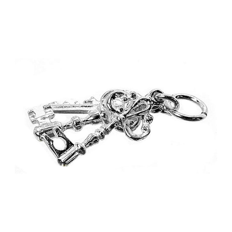 Puede incluir: Un dije plateado con dos llaves ornamentadas. Las llaves tienen dise&ntilde;os detallados, incluyendo un elemento en forma de coraz&oacute;n y patrones decorativos. Un peque&ntilde;o anillo est&aacute; adjunto para facilitar la fijaci&oacute;n a un collar o pulsera.