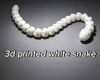 May include: A white articulated snake figure with a segmented body and a smooth finish. The text 3d printed white snake is displayed below the object. The snake is composed of multiple connected pieces that allow for flexible movement.