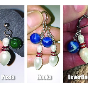 May include: Three pairs of bowling ball earrings with different earring backs: posts, hooks, and leverback. Each earring features a white pearl bowling pin with red rhinestone accents and a blue and white bowling ball charm.