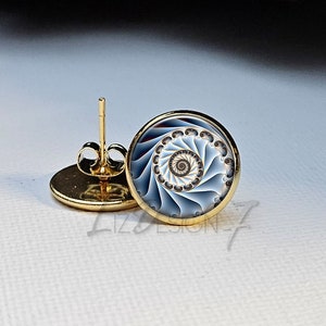 May include: A pair of gold stud earrings with a blue and white spiral design. The earrings are made of metal and have a post back.
