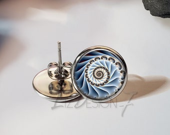 Könnte beinhalten: Ein Paar silberne Ohrstecker mit einem blauen und weißen Spiralmuster. Die Ohrringe liegen auf einem weißen Hintergrund.