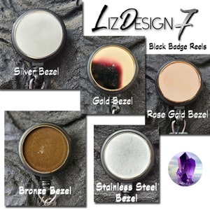 May include: Five different badge reels with black retractable cords and various colored bezels. The bezels are silver, gold, rose gold, bronze, and stainless steel. The text "Liz Design 7 Black Badge Reels" is at the top of the image.