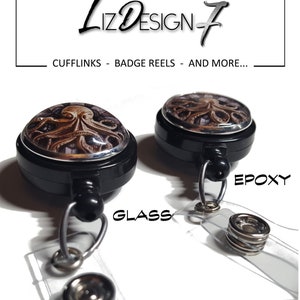 May include: Two black retractable badge reels with a silver rimmed glass and epoxy dome featuring an octopus design. The text "GLASS" and "EPOXY" are printed below the reels.