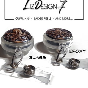 May include: Two retractable badge reels with a graphic of an octopus. The reel on the left has a glass dome and the reel on the right has an epoxy dome. The text "GLASS" is below the left reel and the text "EPOXY" is below the right reel.