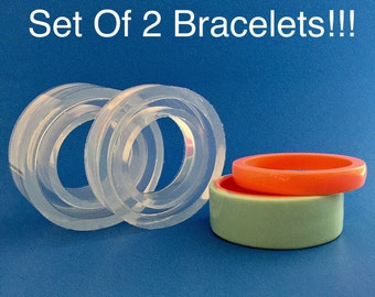 May include: Set of two clear silicone bracelet moulds and two finished bracelets, one green and one orange.