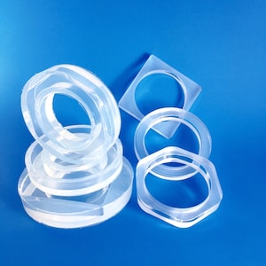 May include: A set of clear plastic rings of various sizes, stacked on top of each other. The rings are smooth and translucent, with a slight sheen.
