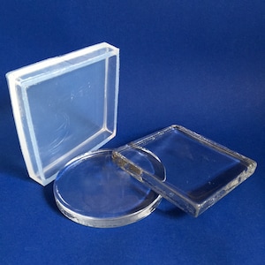 May include: Three clear glass and plastic containers of different shapes and sizes. The containers are on a blue surface.