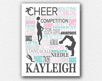 May include: A rectangular wall art print featuring the word CHEER in large black letters, surrounded by various cheerleading terms like TUMBLING, JUMP, and SCORPION in pink, blue, and gray. Silhouettes of cheerleaders are integrated with the text.