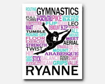 May include: A white rectangular wall art print featuring a black silhouette of a gymnast performing a leap. The background is filled with gymnastics-related words in pink, purple, and teal, including "GYMNASTICS" at the top and "RYANNE" at the bottom.