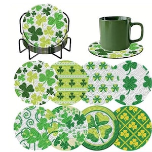 May include: A collection of St. Patrick's Day coasters with shamrock patterns in green and white. The set includes a black metal holder and a green mug on a matching coaster. The coasters feature various shamrock designs in different shades of green.
