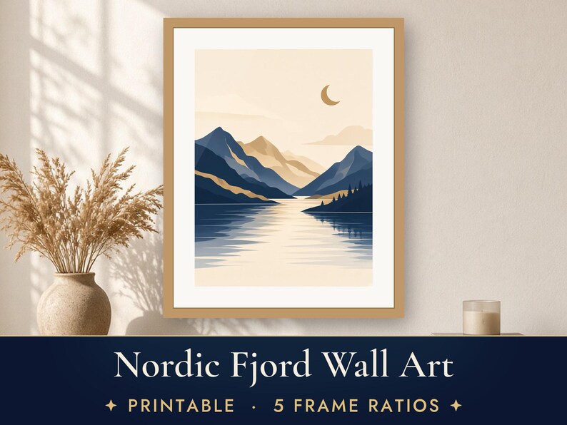 May include: A framed wall art print featuring a landscape illustration of mountains and a lake with a crescent moon in a beige sky. The artwork displays deep blue and tan tones with a reflection on the water surface and a light wood frame.