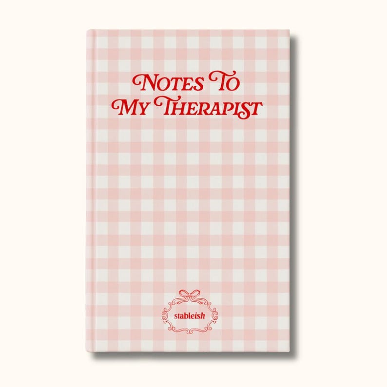 May include: A pink and white gingham-patterned notebook with the text "Notes To My Therapist" in red script. The notebook also features the "stableish" logo in a decorative frame.