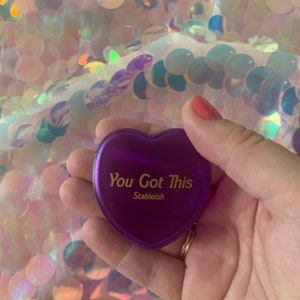 May include: A purple heart-shaped motivational keychain with the text "You Got This" and the word "Stableish" printed in gold lettering.