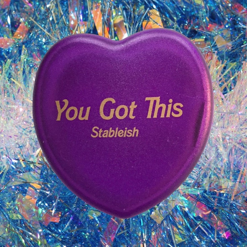 May include: Purple heart-shaped motivational stone with the text "You Got This" and the word "Stableish" below it.
