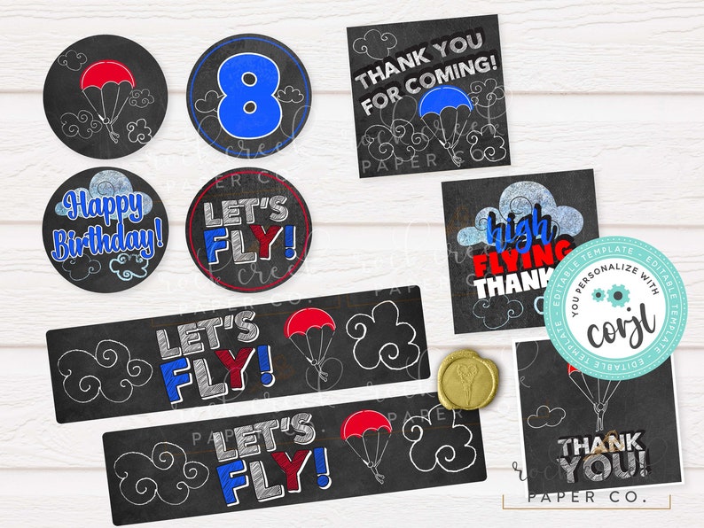 Pu&ograve; includere: Decorazioni per feste stampabili a tema lavagna. Le decorazioni presentano uno schema di colori blu e rosso con nuvole, paracadute e il testo "Let's Fly!" e "Buon compleanno!"