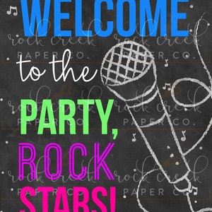 K&ouml;nnte beinhalten: Ein Schild aus schwarzer Tafel mit dem Text "WELCOME to the PARTY, ROCK STARS!" in leuchtenden Farben. Rechts auf dem Schild ist eine wei&szlig;e Kreidezeichnung eines Mikrofons.
