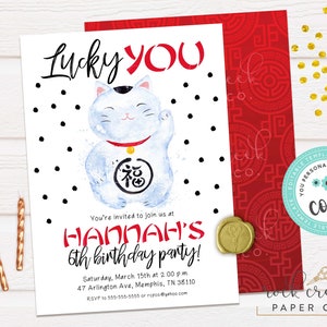 May include: A white invitation card with black polka dots and a watercolor illustration of a lucky cat. The text on the card reads "Lucky You" and "Hannah's 6th birthday party!" with the date, time, and location of the party.