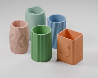 Puede incluir: Un conjunto de cinco organizadores de escritorio cilíndricos en varios colores pastel. El set incluye un soporte rosa con facetas geométricas, una forma orgánica verde claro, un recipiente verde estriado, un vaso azul acanalado y una caja naranja.
