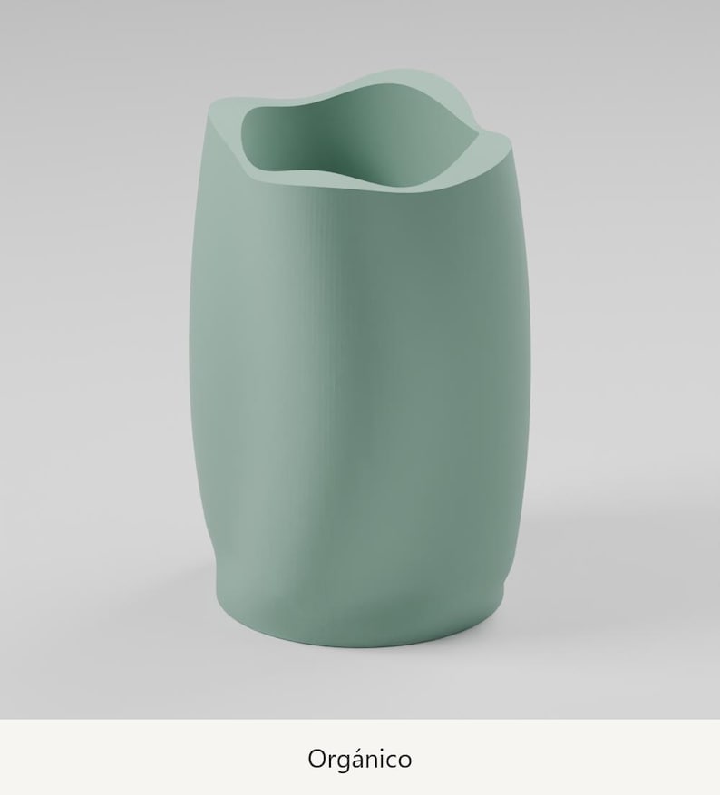 May include: A sage green vase with a smooth, matte finish and an irregular, undulating rim. The vessel features a cylindrical body with soft, flowing curves and a wide opening at the top. The word Org&aacute;nico is printed below the object.