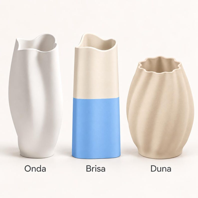 Op de afbeelding: Drie vazen met de labels Onda, Brisa en Duna. De eerste is een hoge witte vaas met een golvende rand. De tweede is een cilindrische vaas met een cr&egrave;mekleurige bovenkant en blauwe onderkant. De derde is een beige, ronde vaas met ribbels.