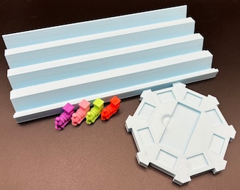 Puede incluir: Un conjunto de cuatro trenes de juguete de colores, rosa, morado, verde y naranja, en una vía azul claro con una plataforma circular azul claro.