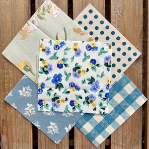 May include: Five fabric swatches with different patterns. The swatches are blue, white and green with floral, polka dot and plaid patterns.