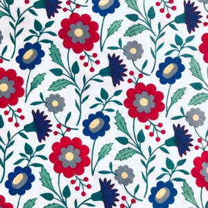 May include: A white fabric with a repeating pattern of red, blue, and gray flowers. The flowers are stylized and have a simple design. The background is white.