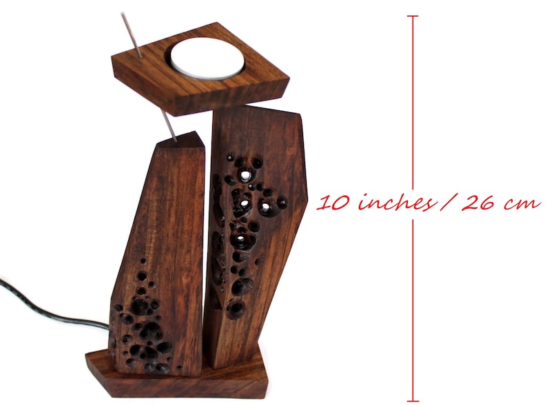 Peut inclure: Un bougeoir en bois avec un motif sculpt&eacute;. Le bougeoir mesure 26 cm de haut et a un emplacement pour une bougie chauffe-plat.