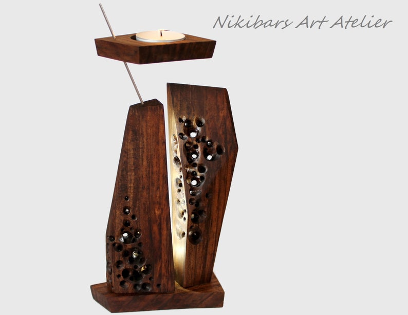Peut inclure: Un bougeoir en bois avec un design unique, comprenant une section sculpt&eacute;e avec une petite bougie sur le dessus. Le bougeoir est en bois brun fonc&eacute; et a un aspect rustique.